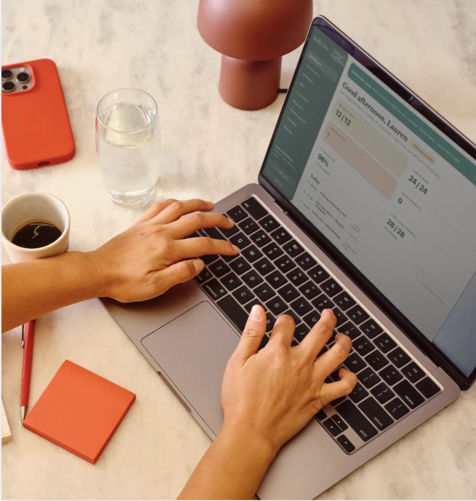 A care manager working through the SoftCare dashboard on a laptop